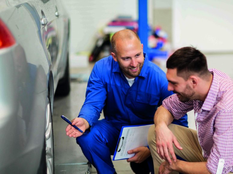 Mechaniker und Kunden besprechen Herstellergarantie beibehalten bei TOP Markenspezialist Autohaus Klöpper. Spezialist für Renault, Dacia